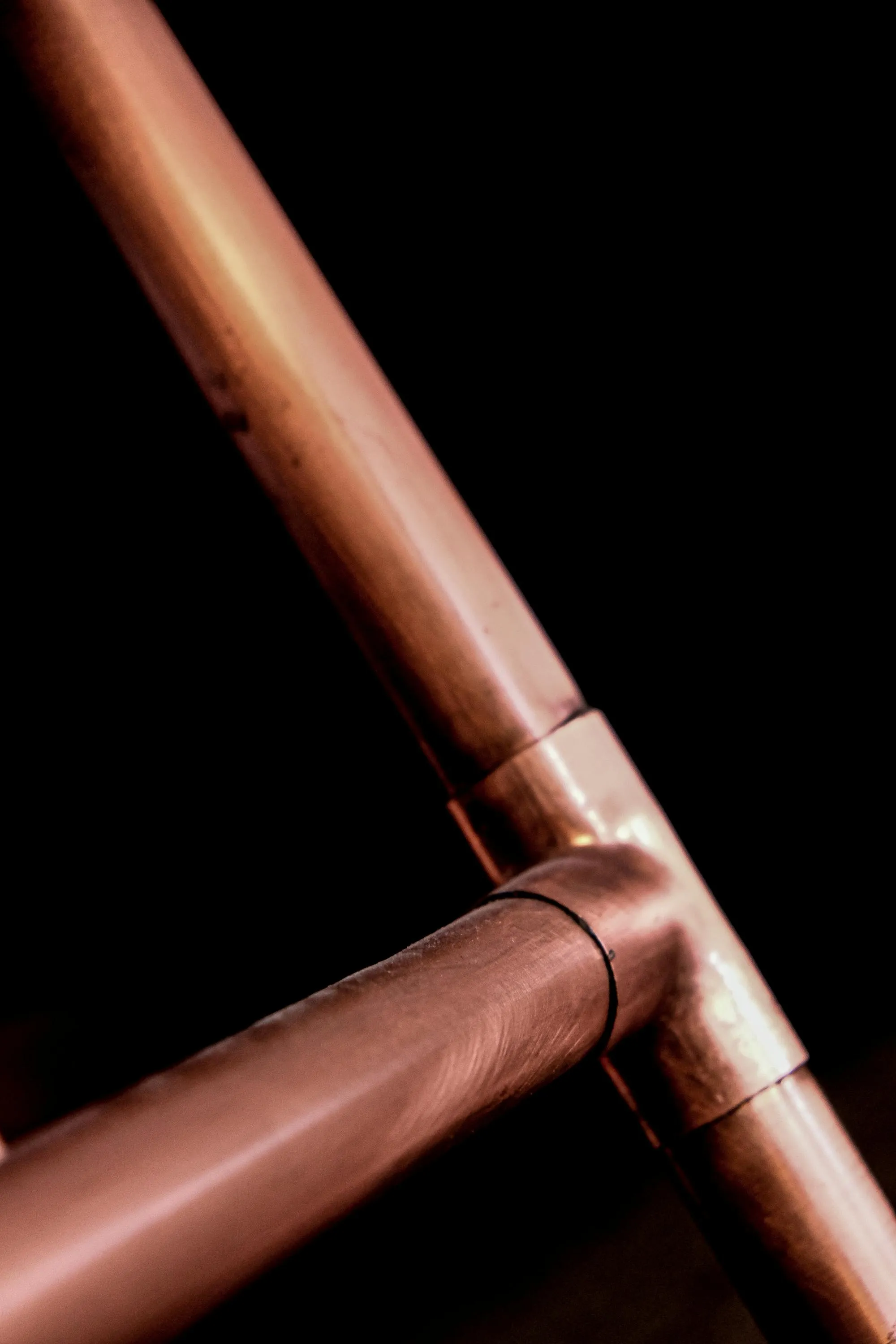 Copper pipework with soldered joints, lit warmly